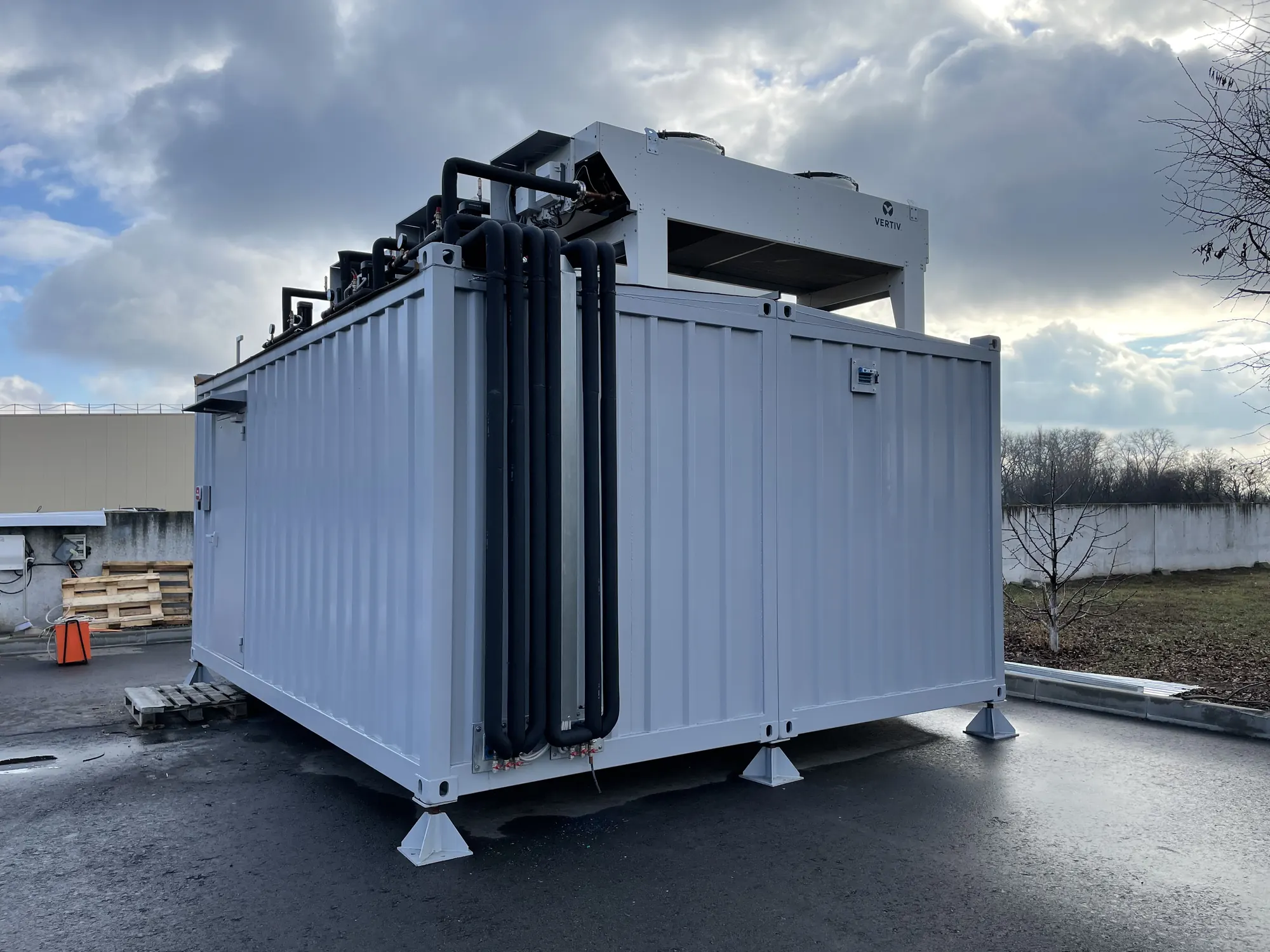 A white ModulEdge modular data center with rooftop cooling equipment on an outdoor pad